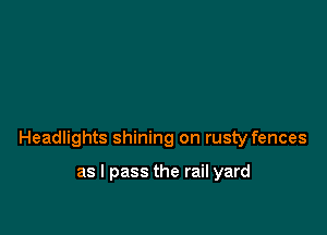 Headlights shining on rusty fences

as I pass the rail yard