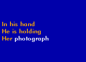 In his hand

He is holding
Her photograph