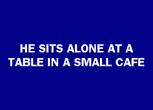 HE SITS ALONE AT A

TABLE IN A SMALL CAFE